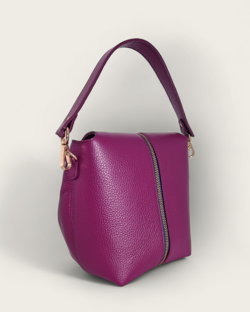 Un sac à main interchangeable rose de chez INVHERA, photo de dos, en cuir de vachette grainé doté d’un zip central doré et d’un ruban bleu nuit. Pour permettre de changer de style en un claquement de doigt. De façon unicolore ou bicolore.