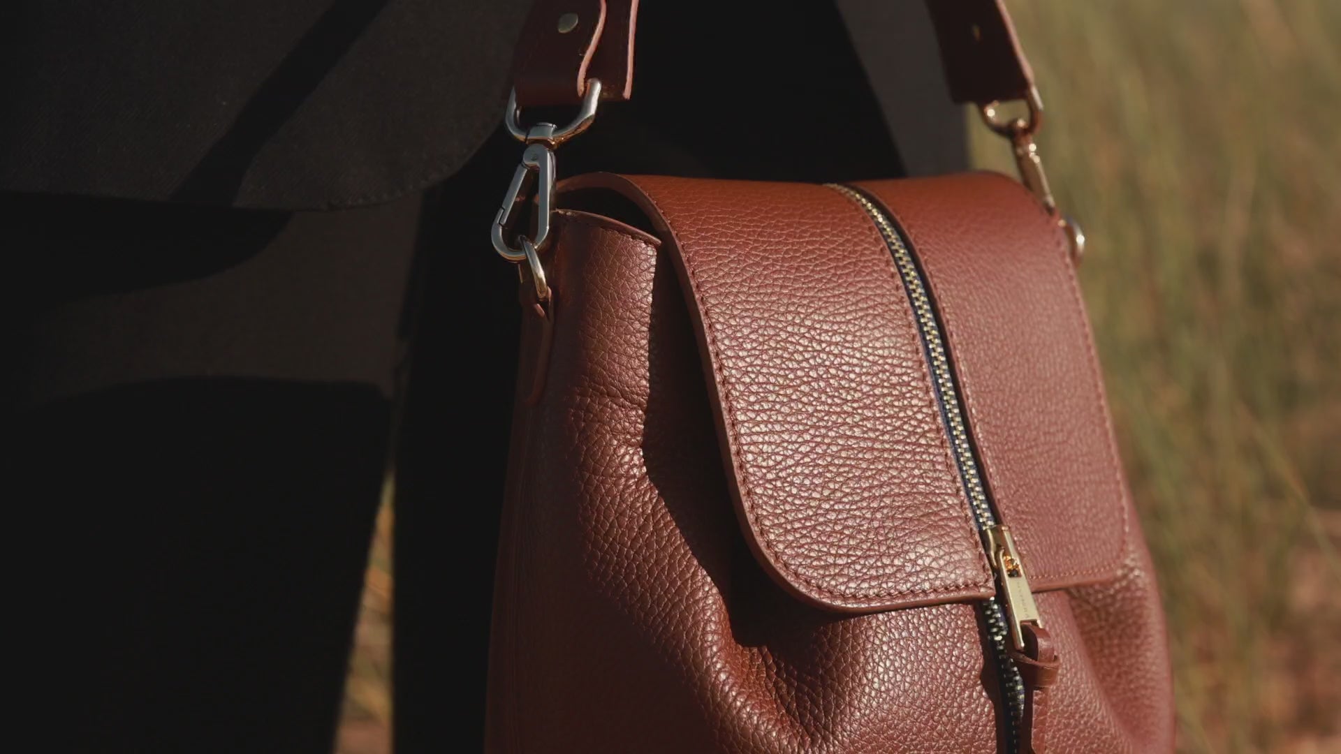 Une vidéo montrant les détails et finitions du sac à main de chez INVHERA; Sac cuir marron italien doté d'un zip central bande bleu nuit avec curseur gravé INVHERA; Son design simple et épuré y cache son côté audacieux grâce à notre système astucieux.