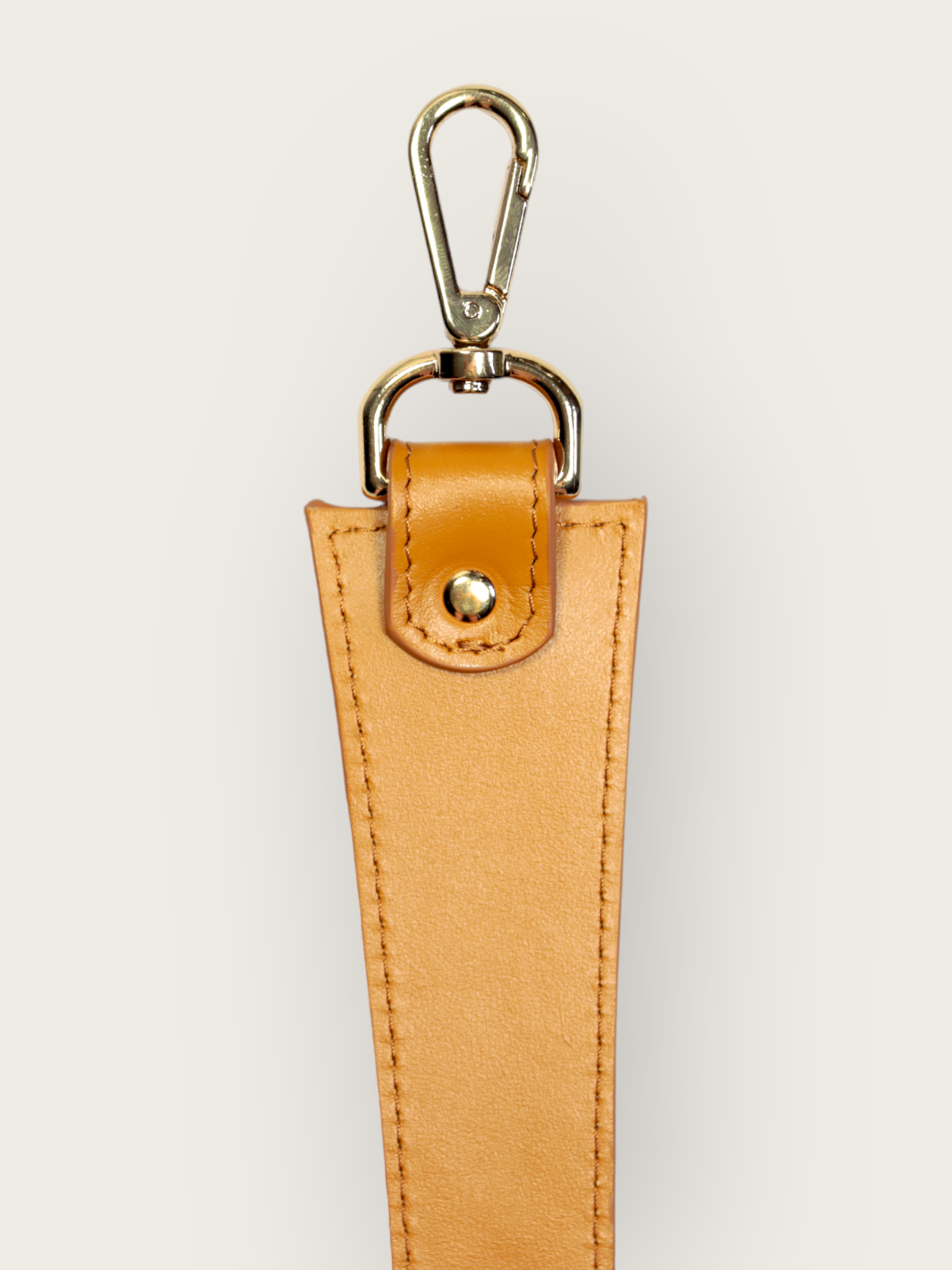Anse cuir de vachette responsable de couleur jaune moutarde pour sac à main de chez INVHERA avec des mousquetons en métal doré, photo de face un accessoire élégant et pratique pour agrémenter votre sac. Fabriqué à partir de qualité, l’anse est résistante et durable. Les mousquetons en métal doré permettent de fixer facilement l’anse à votre sac, assurant ainsi une sécurité optimale. 