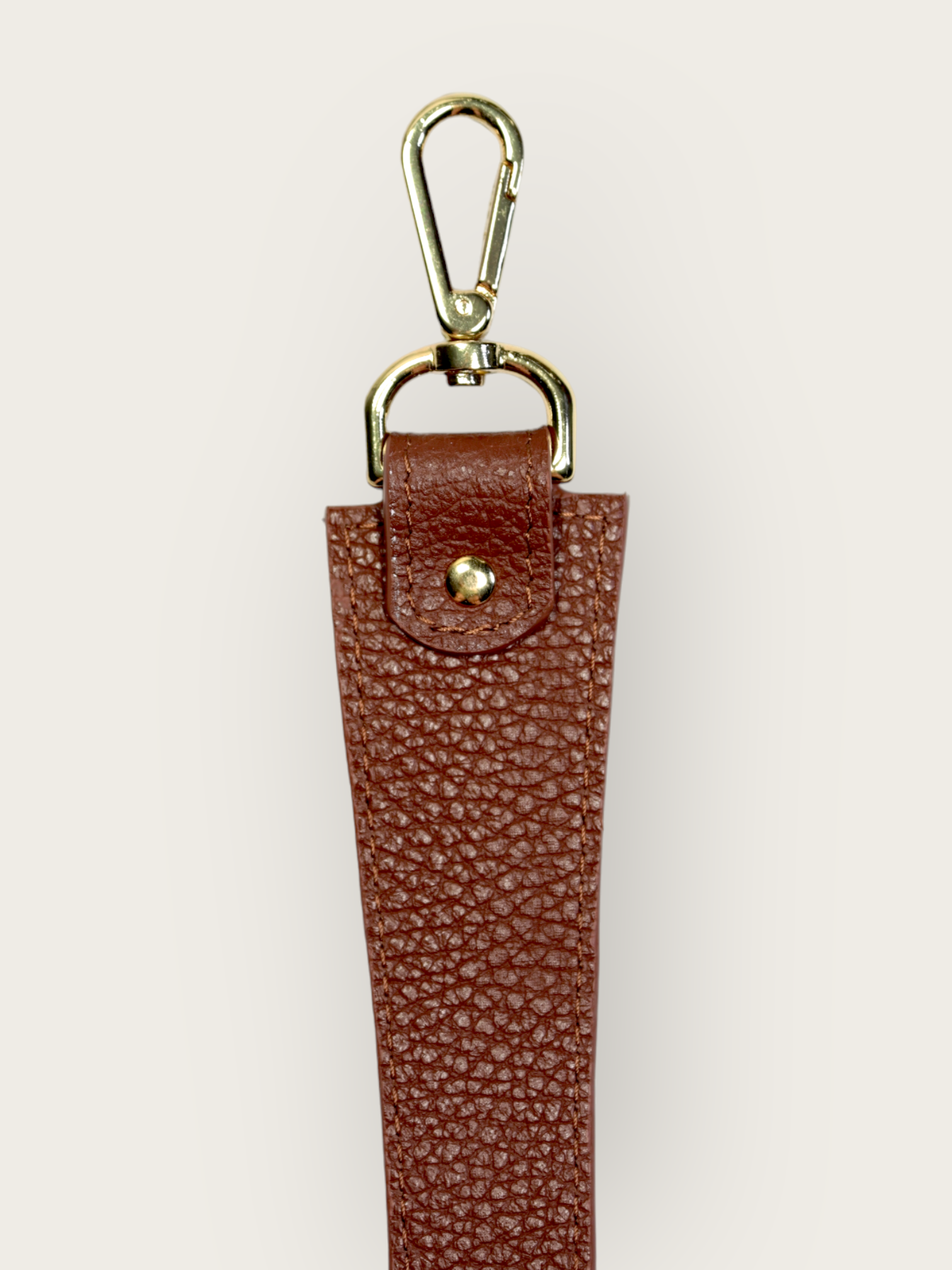 Anse cuir de vachette responsable de couleur marron pour sac à main de chez INVHERA avec des mousquetons en métal doré, photo de face un accessoire élégant et pratique pour agrémenter votre sac. Fabriqué à partir de qualité, l’anse est résistante et durable. Les mousquetons en métal doré permettent de fixer facilement l’anse à votre sac, assurant ainsi une sécurité optimale. 
